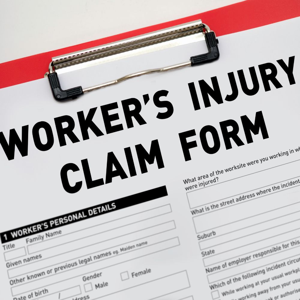 work injury claim form on a red clipboard