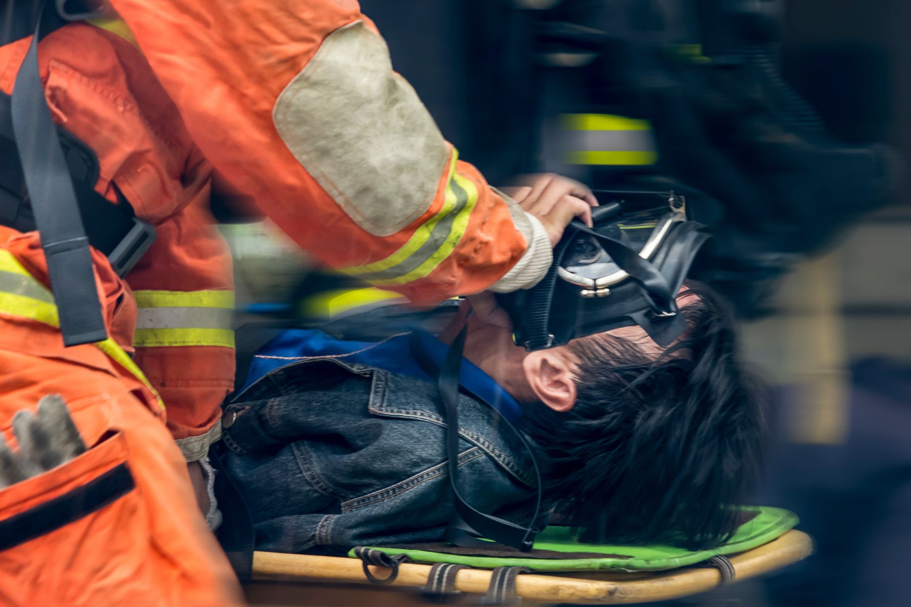 injured worker on a stretcher being assisted by an EMT